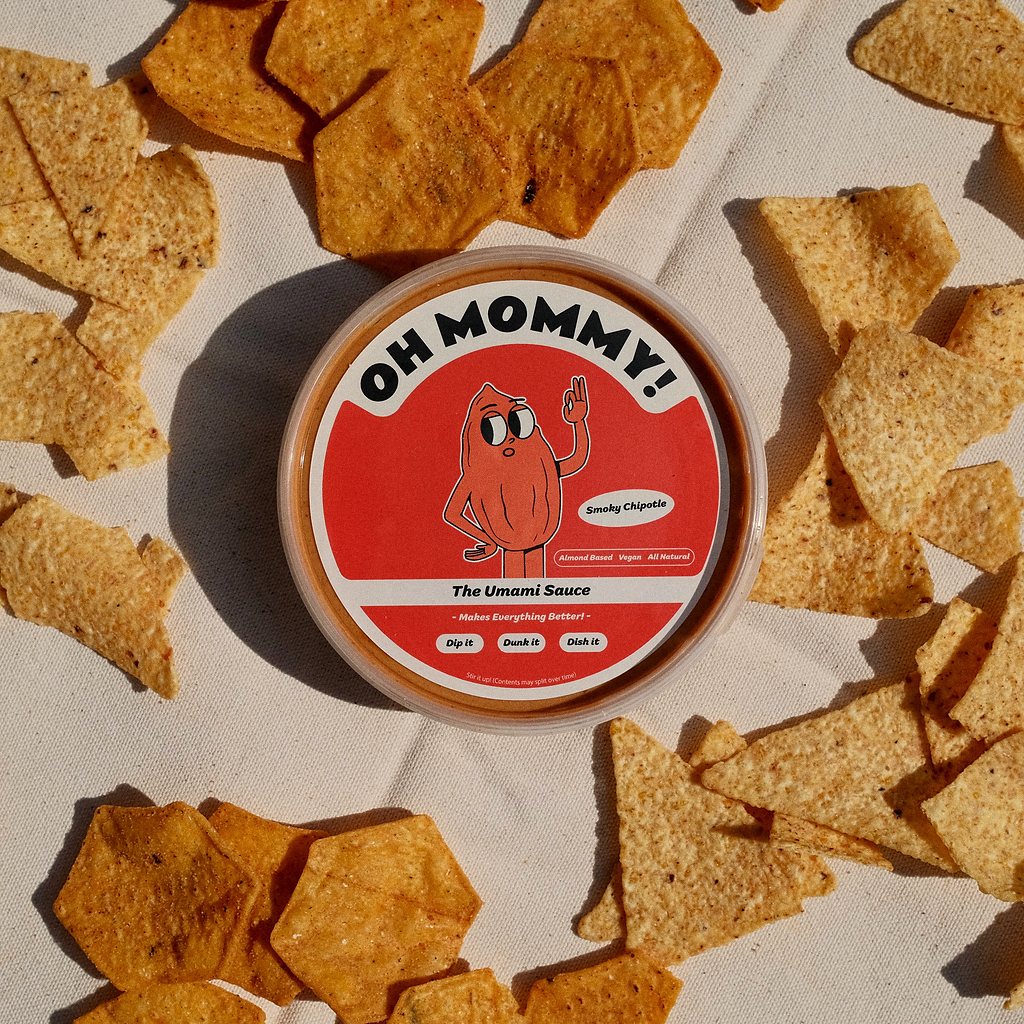 A tub of Oh Mommy! Smoky Chipotle sauce surrounded by tortilla chips.